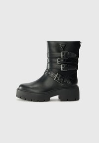 Svarte lær ankle boots med tre spente stropper, teksturerte detaljer, tykk gummisåle og en triangel-logo på forsiden.