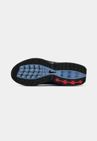 Shoe sole with black and blue tread, red circular accents, and a small black Nike logo in the center.