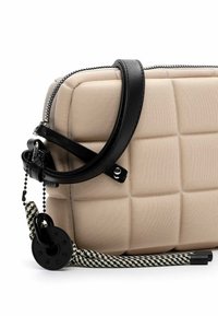 Borsa beige trapuntata con forma strutturata, tracolla in pelle nera, chiusura con zip e una tracolla decorativa intrecciata con un dettaglio in metallo circolare.