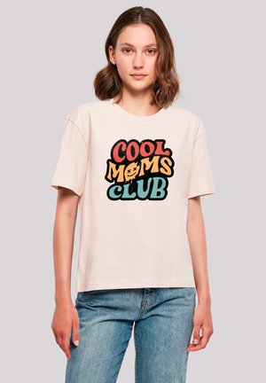 Light pink t-shirt featuring bold, multicolored text "COOL MOMS CLUB" in various playful fonts. Casual, short-sleeve design with a relaxed fit.