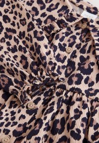 Langærmet kjole med leopardprint, beige knapper, elastiske manchetter og en rundstrikket talje på ribstrikket stof.