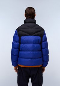 Puffjakke med en sort øverste sektion og en blå nederste sektion med en kviltet design; orange strikdetalje i bunden.