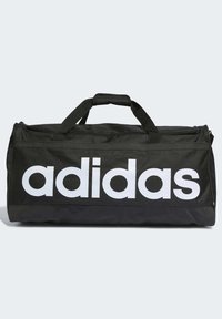 Borsa a tracolla nera realizzata in tessuto resistente, con grande logo "adidas" bianco, doppie maniglie e chiusura con zip. Texture complessivamente liscia.