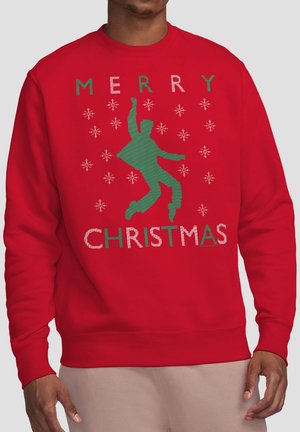 Roter Weihnachtspullover mit grünem tanzendem Motiv und weißen Schneeflocken, mit dem Schriftzug "Frohe Weihnachten" in grünen und weißen Buchstaben.
