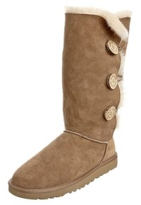Brązowy zamszowy kozaki do kolan z puszystym białym futrzanym obszyciem, okrągłymi drewnianymi guzikami po boku i płaską gumową podeszwą.