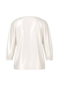 White satin top with a relaxed fit, long puff sleeves, and gathered cuffs. Smooth texture, round neckline, and no visible fasteners.