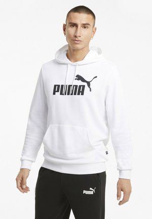 Hvid hoodie med hætte, prydet med et stort sort "PUMA" logo og en sort springende pumagrafik. Kombineret med sorte bukser, også med "PUMA" branding.