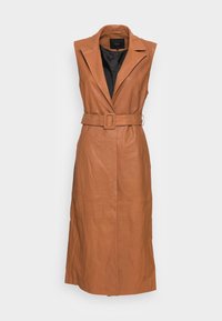 Chaleco de cuero de color marrón claro sin mangas con cuello, cintura ceñida y un diseño largo y fluido. El interior está forrado con tela negra.