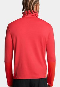 Rotes, langärmliges Sportoberteil mit Stehkragen, glatter Textur und kontrastierenden Ärmeln. Verfügt über flache Nähte für zusätzlichen Komfort und eine enganliegende Passform.