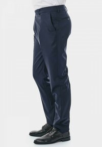 Pantalons bleu marine avec une coupe ajustée, tissu lisse, poches latérales et une poche arrière, associés à des chaussures en cuir noir.