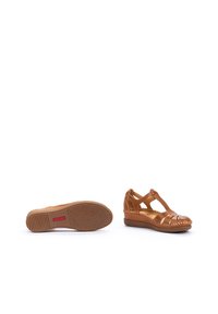 Zapatos de cuña de cuero marrón con un diseño de tiras, plantilla texturizada y suela de goma con patrón, que cuentan con un tacón bajo y punta abierta.