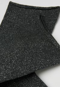 Schwarze glitzernde Socken aus strukturiertem Stoff mit schimmerndem Effekt, mit einem Rippenmuster und einem weichen Finish.