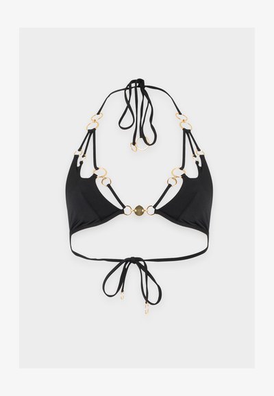 Haut de bikini noir avec des anneaux dorés reliant les bretelles, attaches autour du cou et fermeture par nœud papillon dans le dos sur un fond uni.