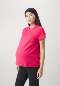 Zwangerschaps T-shirt in levendig roze, korte mouwen, ronde halslijn, gemaakt van zachte katoen, op maat gemaakt voor een comfortabele pasvorm over de buik.