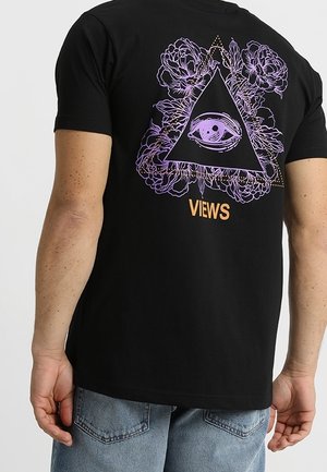 Musta puuvillapaita, jossa on violetti kukkakolmio design, silmä ja sana "VIEWS" oranssina selässä.