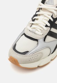 Chunky Sneakers mit weißem Mesh, grauem Wildleder und schwarzen Synthetik-Akzenten. Verfügt über eine strukturierte Gummisohle und Details aus beige-gummiertem Material.