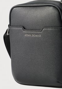 Μαύρο δερμάτινο τσαντάκι χιαστί με υφή, με μπροστινή τσέπη και ασημένιο λογότυπο "Armani Exchange", που διαθέτει ρυθμιζόμενο μαύρο ιμάντα.