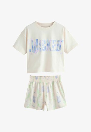 Krémový top s krátkým rukávem s nápisem „LUCKED“ modrými květinovými písmeny a odpovídajícími šortkami se zeleným vinným motivem a modrým květinovým vzorem.