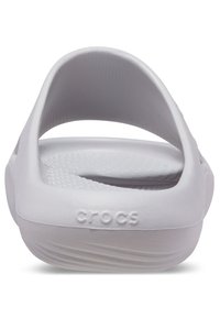 Sandal in gomma bianca con suola testurizzata e fascia posteriore. Il marchio "crocs" è impresso sul lato.