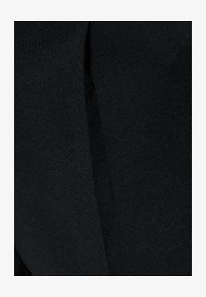 Tela negra con una textura suave, que presenta un brillo sutil y un pliegue a lo largo de un lado, indicativo de un diseño a medida.