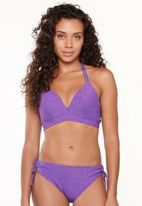 Ensemble de bikini violet avec une texture scintillante, un soutien-gorge triangle avec des bretelles ajustables, et un bas hipster à liens sur les côtés.