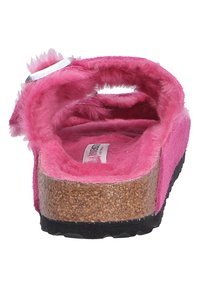 Fuchsia pink clog with soft fabric lining, cork footbed, and black rubber sole. Open back design with strap and metal buckle accents.