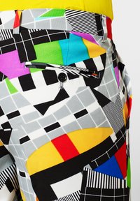 Multicolored pants featuring a geometric pattern with bold colors including red, yellow, blue, and green, constructed from a smooth fabric.