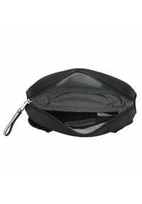 Bolsa negra con un exterior suave, cremallera de metal y forro de tela. El interior tiene dos bolsillos sin cierre y una etiqueta de logo. Diseño plano para un almacenamiento fácil.