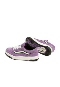 Lila mockaskor med vita snören, svarta detaljer och en texturerad gummisula. Har en klassisk design med perforerade detaljer.