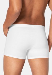Weiße Baumwoll-Boxershorts mit enger Passform, ausgestattet mit einem weichen Bund und glatter Textur. Das Design ist minimalistisch und hat keine Muster.