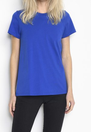 Korte mouwen, effen blauwe T-shirt van katoen, met een ronde hals en rechte zoom. Gecombineerd met zwarte skinny jeans.