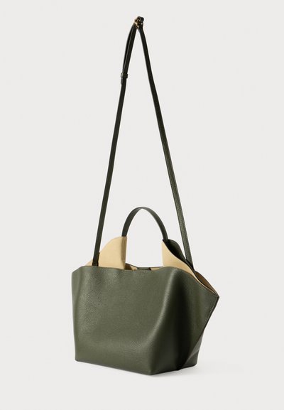 Grøn læder tote bag med struktureret overflade, to hanke og åbent top. Indvendigt afsløres et kontrastfuldt beige for og minimal struktur.