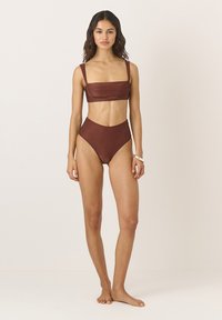 Strój bikini w głębokim odcieniu rdzy, składający się z bluzki z kwadratowym dekoltem i szerokimi ramiączkami oraz majtek z wysokim stanem, obie części wykonane z teksturowanej tkaniny.