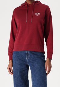 Sudadera burdeos de mezcla de algodón, con un bolsillo tipo canguro, capucha ajustable con cordón y el logo blanco "GANT 1949" en el pecho.