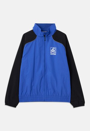 Blauwe en zwarte windbreakerjas met hoge kraag, elastische manchetten, voorrits, zijzakken en logo op de borst. Glad textuur van de stof.