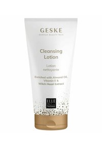 Witte knijptube met gouden accenten, met de tekst "Reinigingslotion", verrijkt met amandelolie, vitamine E en toverhazelaar-extract.