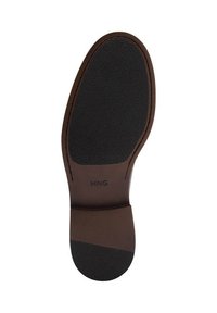 Brown leather shoe sole with a textured black rubber area, featuring a stitched border and "MNG" branding on the heel.
