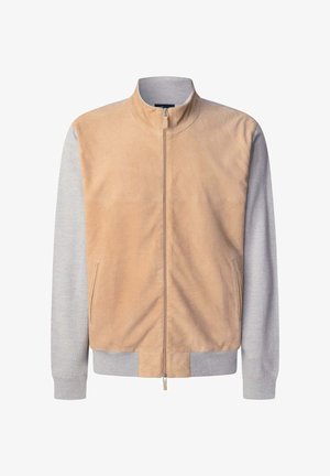 Jasnobrązowa zamszowa kurtka z szarymi dzianinowymi rękawami i prążkowanymi mankietami. Posiada stojący kołnierz oraz centralny zamek, a także kieszenie po bokach.