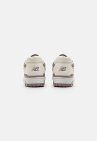 White and lavender New Balance sneakers featuring a smooth leather upper, rubber sole, padded collar, and logo detailing on the back.