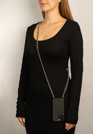 Schwarzfarbene Handytasche mit Kettenriemen, quer über die Brust getragen. Die Tasche verfügt über eine strukturierte Oberfläche und Aussparungen für die Kamera und Tasten.