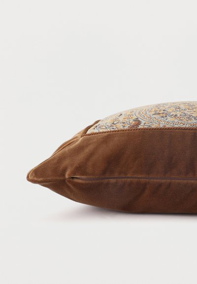 Coussin rectangulaire avec des côtés en tissu velouté marron et un panneau supérieur présentant un motif paisley multicolore détaillé.