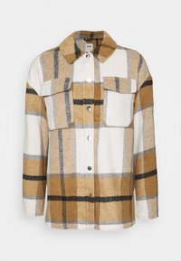 Beige, vit och svart rutigt knappjacka med stora bröstfickor och krage, tillverkad av mjukt ull-liknande tyg.