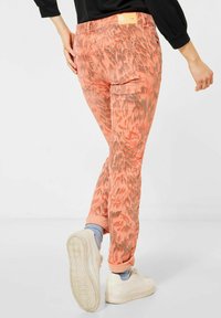 Korallmönstrade jeans med borstad yta och uppvikta benslut. Bakre sidan har två fickor och en etikett vid midjan.