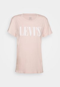 Camiseta de algodón rosa con mangas cortas y cuello redondo, con un gran logotipo en blanco de "LEVI'S" impreso en el pecho.