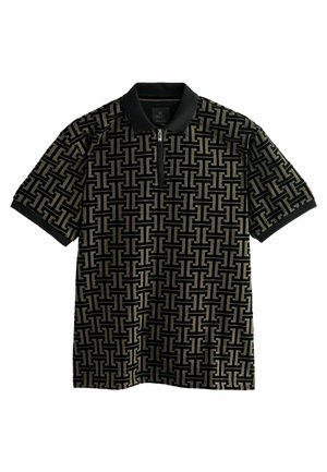Le polo à manches courtes présente un motif géométrique noir et or, une fermeture éclair et un col côtelé noir en tissu texturé.