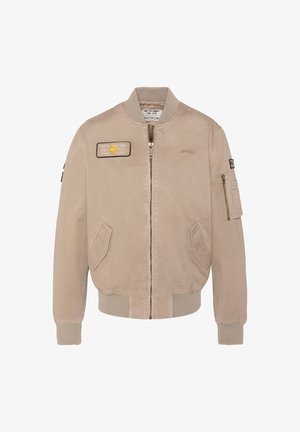 Veste bomber beige avec fermeture éclair frontale, deux poches obliques, poignets et ourlet côtelés, poche zippée sur la manche, et patchs brodés sur la poitrine et le bras.