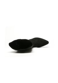 Czarne zamszowe botki do kostki z ostrym noskiem, gładką fakturą i designem typu slip-on. Wnętrze jest widoczne z perforowanym wykończeniem.