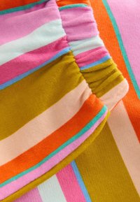 Tissu rayé multicolore avec une texture en coton doux. Les motifs incluent des rayures rose, orange, jaune et bleu clair avec des détails froncés.
