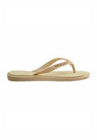 Sandale flip-flop tan avec semelle texturée, fines lanières et détail logo. Fabriquée en matériau flexible avec une semelle extérieure nervurée pour une meilleure adhérence.