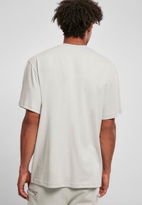 Lys grå bomull t-skjorte med rund hals, korte ermer og en avslappet passform. Glatt tekstur med et enkelt, uornamentert design.